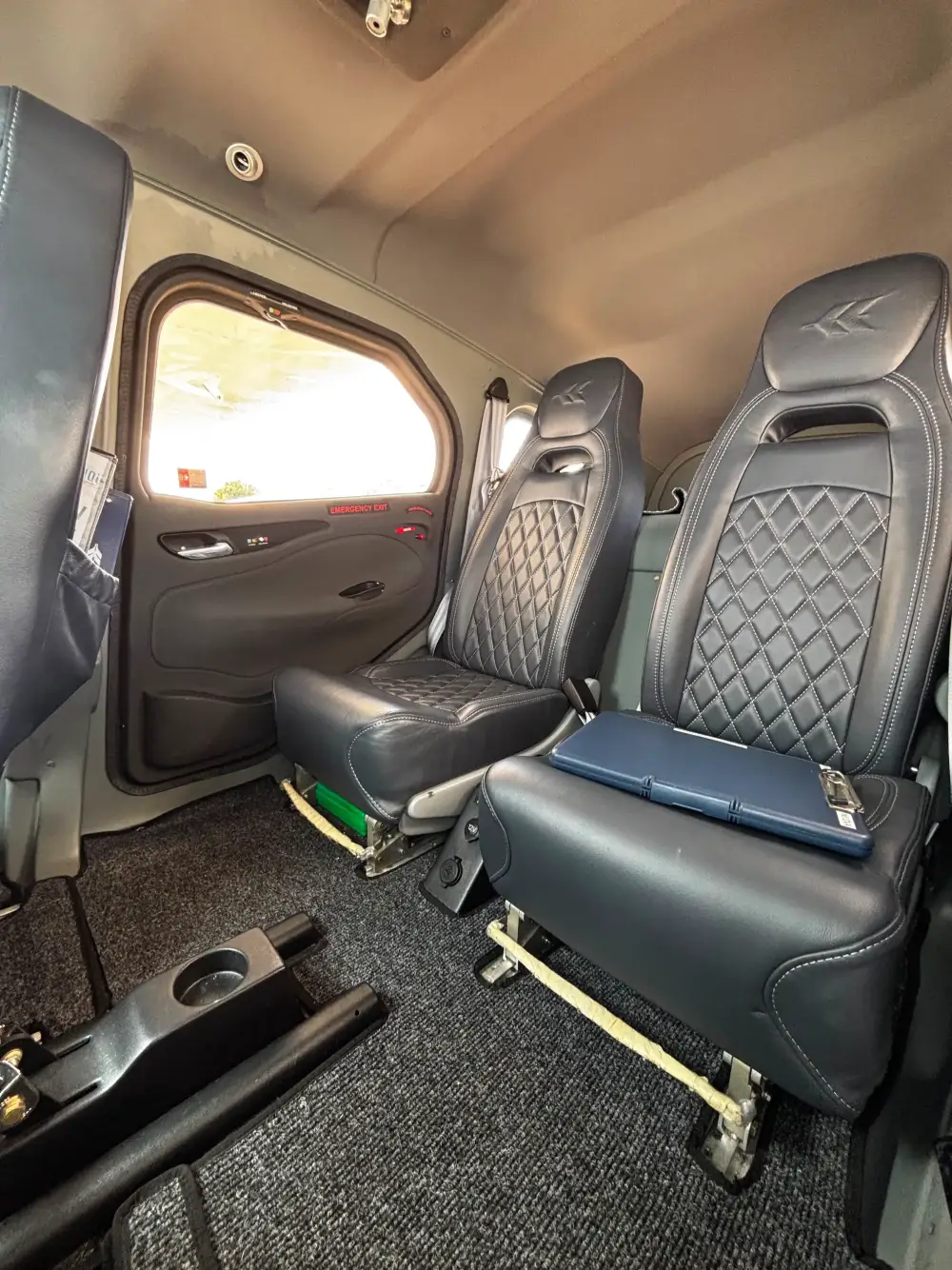Aircraft cabin interior with black quilted leather seats and carpeted floor