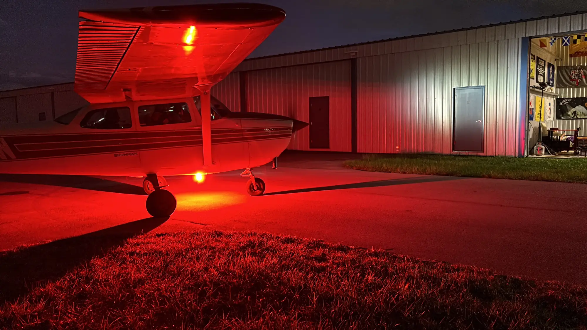 Airplane illuminated by red light at night