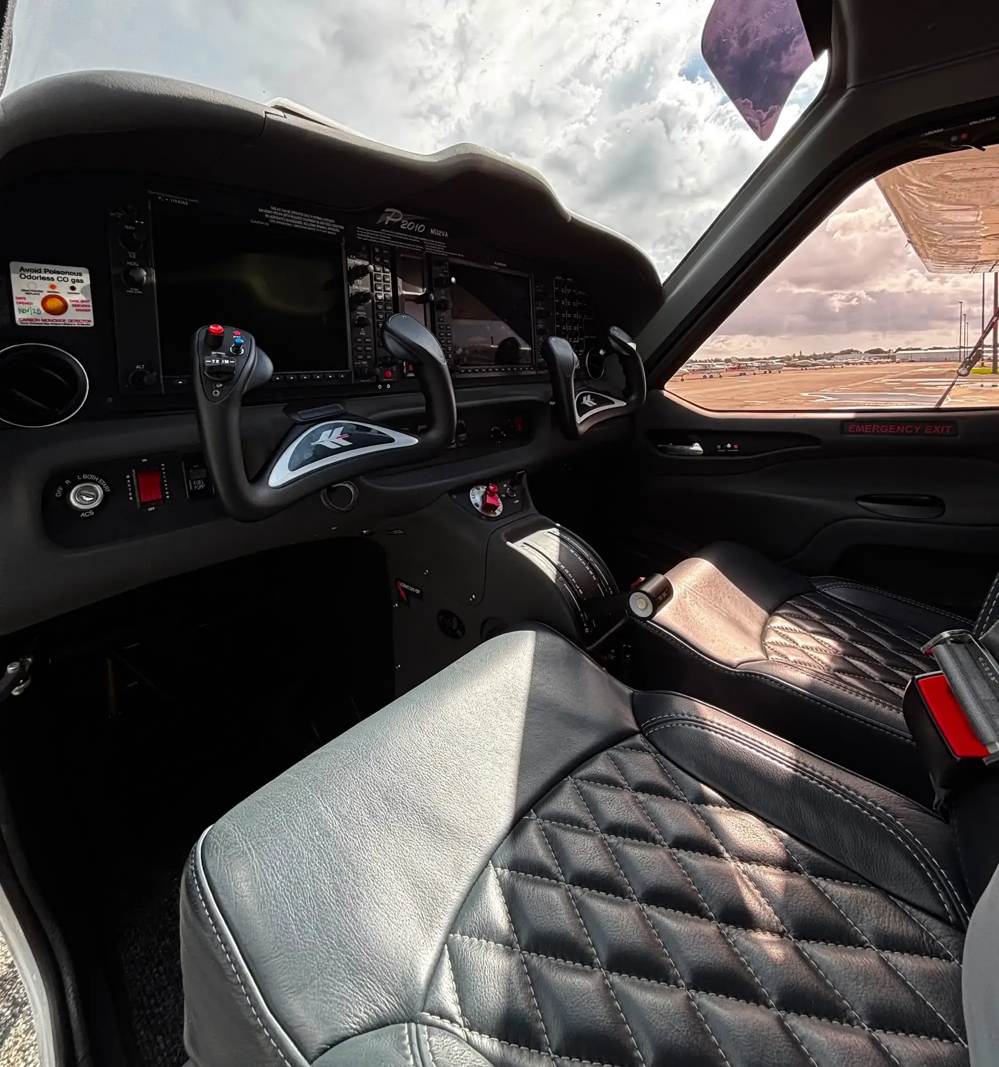Modern aircraft cockpit with quilted leather seats and dual control yokes