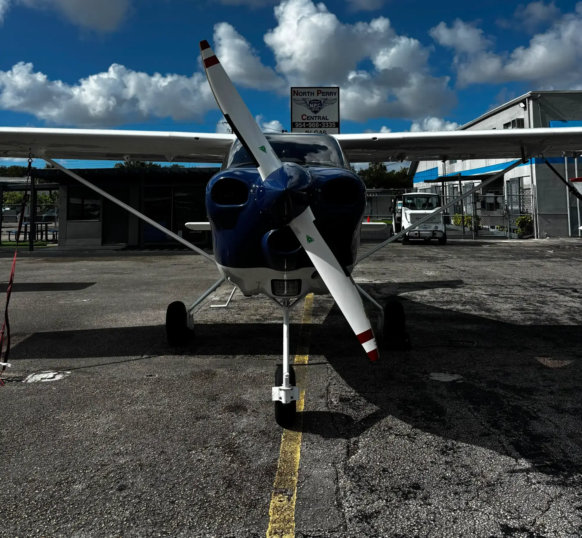 Front view of a single-engine airplane parked on an apron