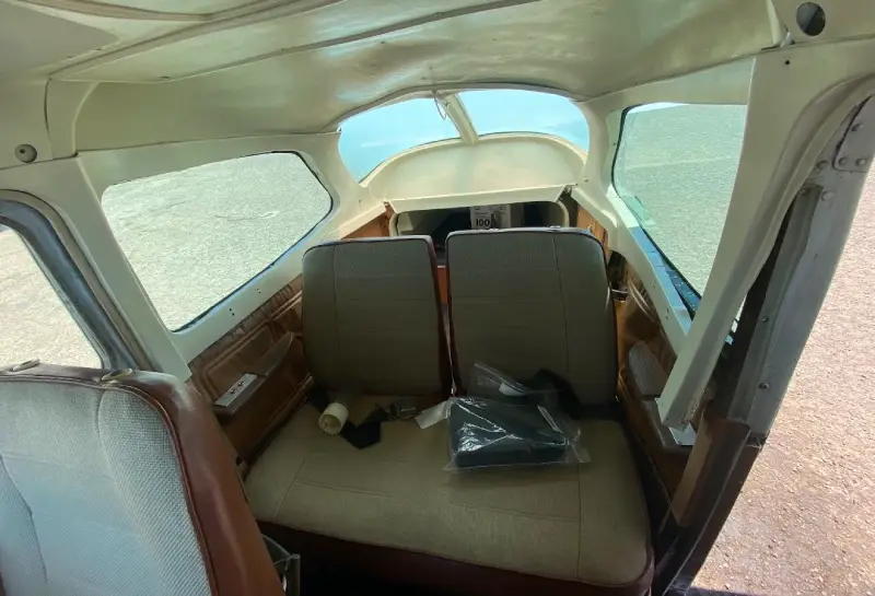Interior view of a small aircraft cabin with tan seats
