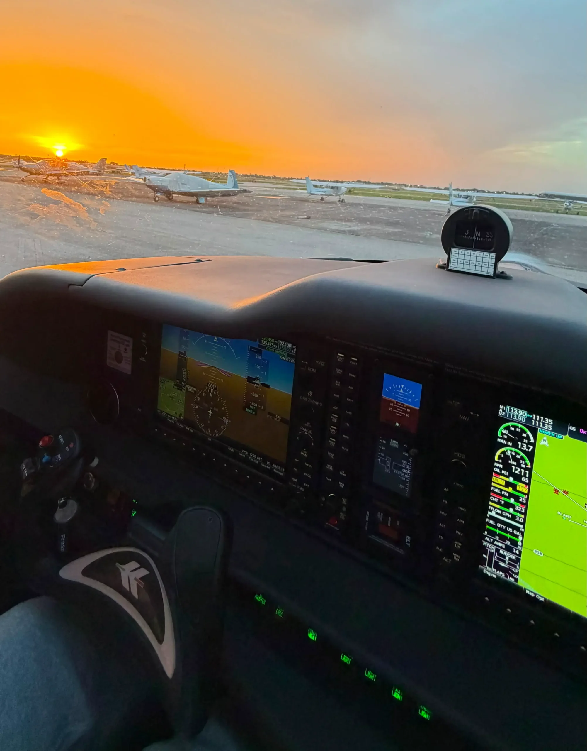 Glass cockpit instrument panel of an airplane during sunset